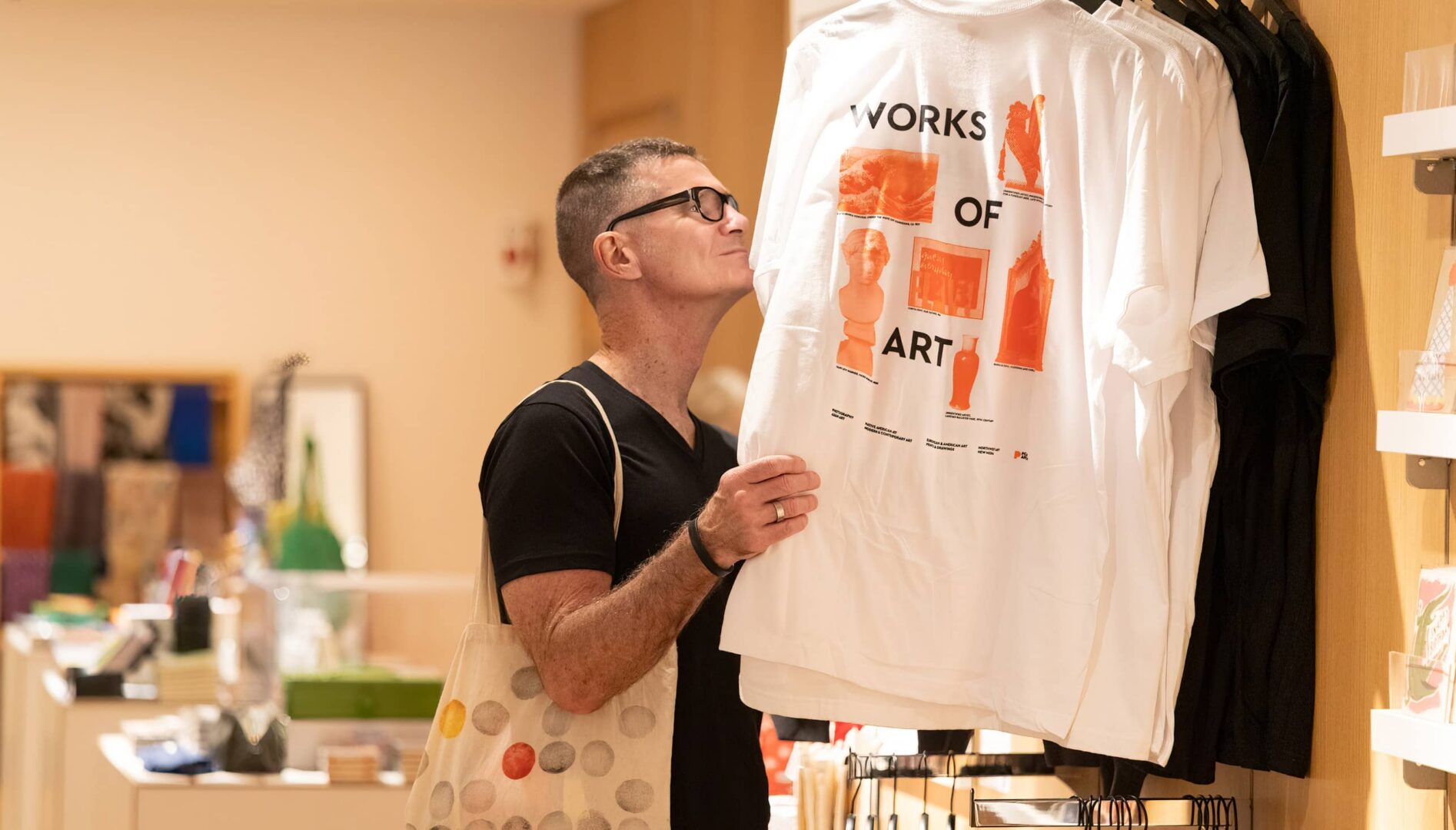 A person looking at shirts on a clothing rack.