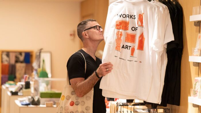 A person looking at shirts on a clothing rack.