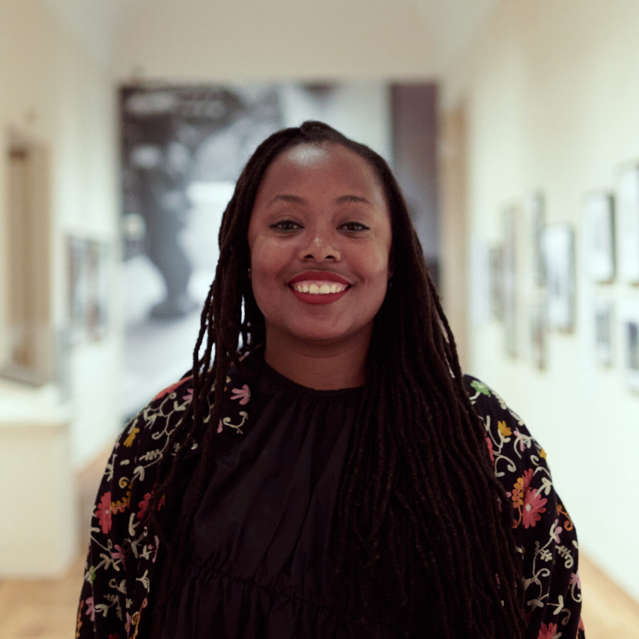 Photo of a Black woman smiling in a gallery.