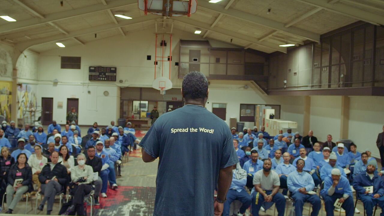 Film still of a man speaking to a crowd.