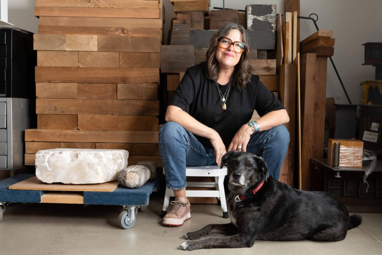 A person sitting with a dog at their feet.