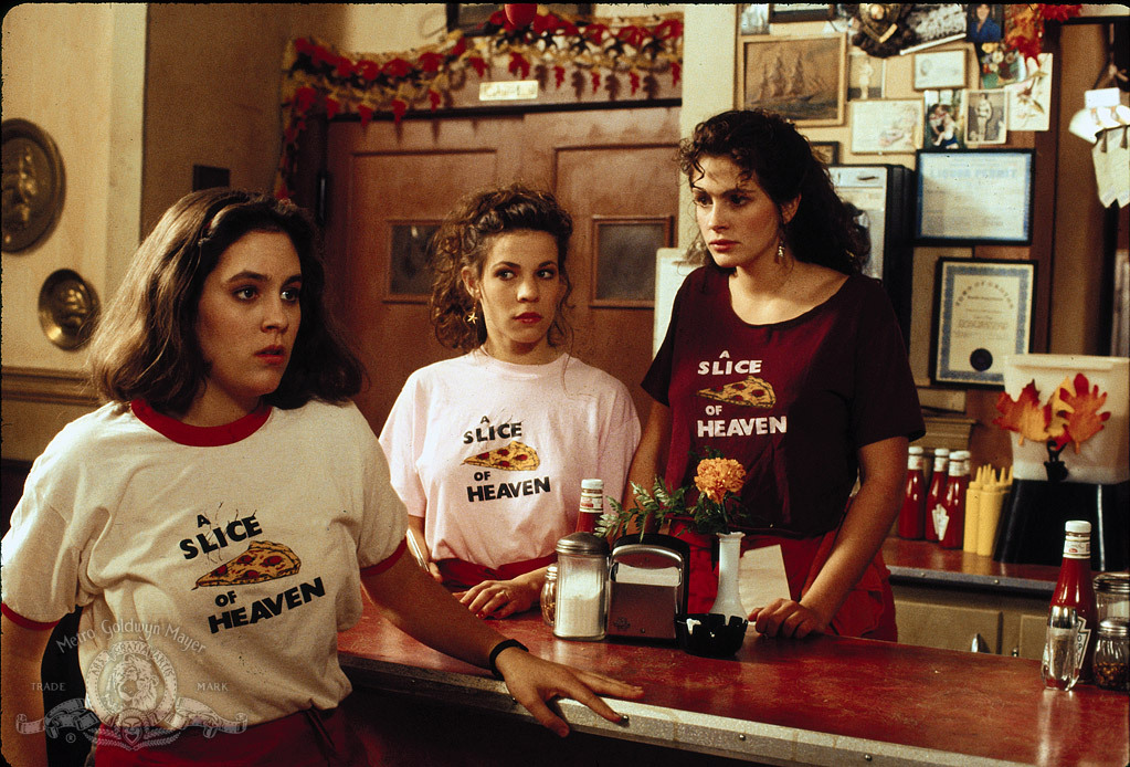 Film still of three women in shirts that say "A Slice of Heaven".