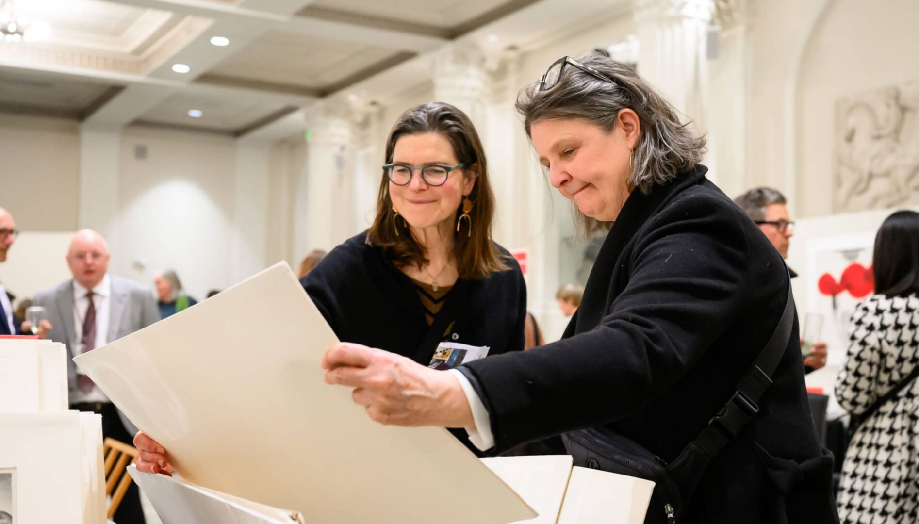 Two people looking at prints.